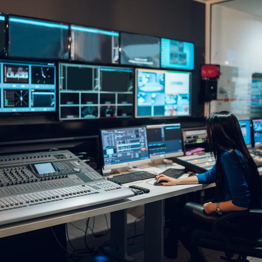 Middle aged woman using equipment in control room on a tv station